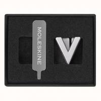 Moleskine Pins V Sølv Nu kan du gøre din notesbog endnu mere personlig ved at fastgøre et symbol til den elastiske lukning. Vælg mellem flere bokstaver og symboler i enten guld eller sølv. Perfekt når du leder efter en lille gave til dig selv eller nogen 